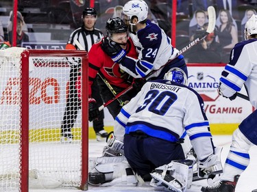 Ottawa Senators left wing Brady Tkachuk (7) battles with Winnipeg Jets defenceman Derek Forbort (24) during first- period NHL action at the Canadian Tire Centre on Wednesday, April 14, 2021.