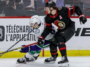 Ottawa Senators defenceman Thomas Chabot (72) checks Vancouver Canucks centre Tyler Motte (64) during the second period at the Canadian Tire Centre on Wednesday, April 28, 2021.