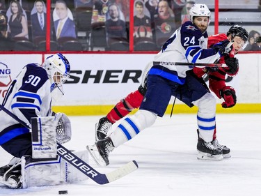 Ottawa Senators left wing Brady Tkachuk (7) battles with Winnipeg Jets defenceman Derek Forbort (24) and manages to get a shot on goaltender Laurent Brossoit.