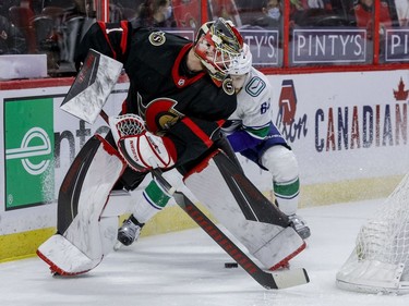 Ottawa Senators goaltender Marcus Hogberg (1) loses a puck battle behind his net with Vancouver Canucks centre Tyler Motte (64).