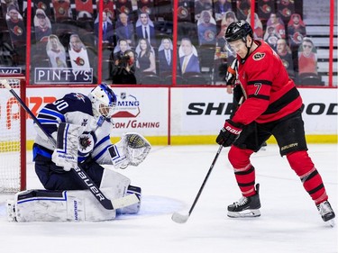 Ottawa Senators left wing Brady Tkachuk (7) deflects the puck into the crest of Winnipeg Jets goaltender Laurent Brossoit.