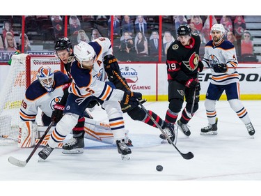 Ottawa Senators left wing Brady Tkachuk (7) and Edmonton Oilers defenceman Adam Larsson (6) battle for a loose puck in front of Edmonton Oilers goaltender Mikko Koskinen (19) as Drake Batherson (19) and defenseman Kris Russell (4) follow the play.