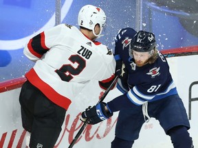 Winnipeg Jets forward Kyle Connor (right) is bumped by Ottawa Senators defenceman Artem Zub in Winnipeg on Mon., April 5, 2021.