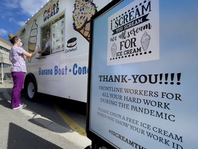 A healthcare worker at The Children’s Hospital of Eastern Ontario gets a free cone from an ice cream truck outside the hospital.