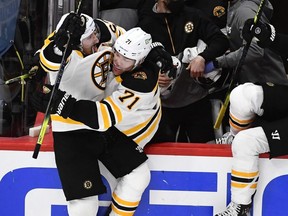 Bruins centre Brad Marchand (left) reacts after scoring the winning goal against the Capitals during the first overtime period in Game 2 of the first round of the 2021 Stanley Cup Playoffs at Capital One Arena in Washington, Monday, May 17, 2021..