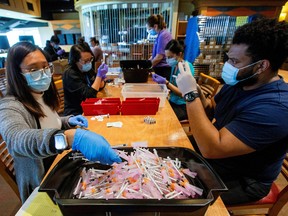 Healthcare workers prepare doses of the Pfizer/BioNTech coronavirus disease (COVID-19) vaccine.