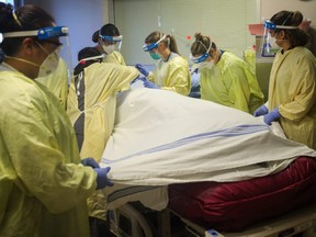 A patient with COVID-19 gets cared for at Peter Lougheed Centre hospital in Calgary, Nov. 14, 2020.