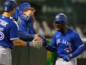 Pinch runner Jonathan Davis celebrates with his teammates after scoring a run as the Blue Jays beat the Athletics on Wednesday night. GETTY IMAGES