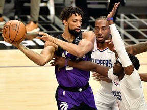 Toronto Raptors centre Khem Birch (24) passes the ball around tight defence by LA Clippers guard Reggie Jackson (1) during the first quarter at Staples Center.