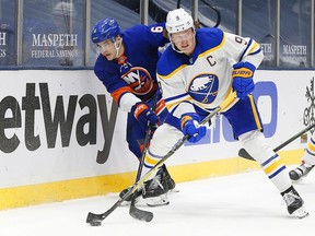 Buffalo Sabres centre Jack Eichel and New York Islanders defenceman Ryan Pulock battle for the puck during the third period at Nassau Veterans Memorial Coliseum, Feb. 22, 2021.