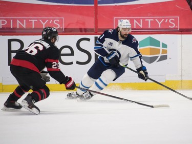 Winnipeg Jets center Nate Thompson (11) skates with the puck in front of Ottawa Senators defenceman Erik Brannstrom (26) in the first period at the Canadian Tire Centre.