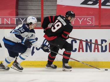 Winnipeg Jets centre Mark Scheifele (55) battles with Ottawa Senators right wing Drake Batherson (19) in the second period at the Canadian Tire Centre.