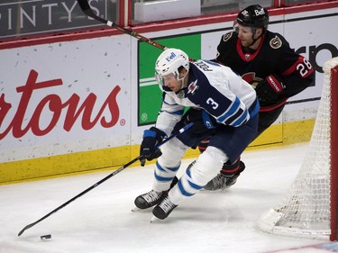 Winnipeg Jets defenceman Tucker Poolman (3) skates with the puck in front of Ottawa Senators right wing Connor Brown (28) in the third period at the Canadian Tire Centre.
