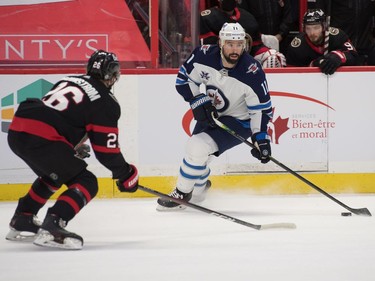 Winnipeg Jets centre Nate Thompson (11) skates with the puck in front of Ottawa Senators defenceman Erik Brannstrom (26) in the first period at the Canadian Tire Centre.
