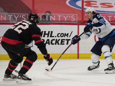 Winnipeg Jets centre Mark Scheifele (55) shoots the puck past Ottawa Senators defencema Nikita Zaitsev (22) in the first period at the Canadian Tire Centre.