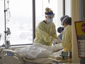 Nurses at a bed in an intensive care unit.