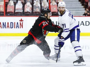 Ottawa Senators defenceman Erik Brannstrom (26) checks Toronto Maple Leafs left wing Nick Foligno.