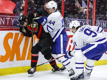 Ottawa Senators centre Shane Pinto (57) is checked by Toronto Maple Leafs defenceman Morgan Rielly (44) and centre John Tavares (91).