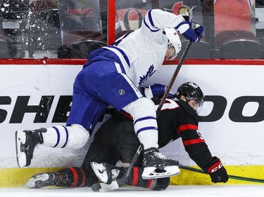 Ottawa Senators centre Shane Pinto (57) and Toronto Maple Leafs defenceman Morgan Rielly battle along the boards.