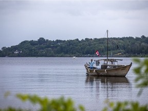 A man on his boat while on the Ottawa River by Petrie Island Beach, Saturday, June 26, 2021.