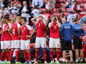 Denmark's players react as paramedics attend to Denmark's midfielder Christian Eriksen after he collapsed on the pitch during the UEFA EURO 2020 Group B football match between Denmark and Finland at the Parken Stadium in Copenhagen on June 12, 2021.