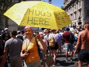An anti-lockdown and anti-vaccine demonstrator holds up an umbrella as she takes part in a protest in Downing Street, amid the COVID-19 pandemic, London, June 14, 2021.