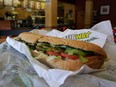 A Subway sandwich is seen in a restaurant as the company announced a settlement over a class-action lawsuit that alleged that Subway engaged in deceptive marketing for its 6-inch and 12-inch sandwiches and served customers less food than they were paying for on October 21, 2015 in Miami, Florida.