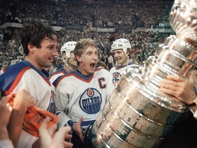 Oilers captain Wayne Gretzky and Paul Coffey get ready to hoist the Stanley Cup during the presentation in Edmonton on May 31, 1985.