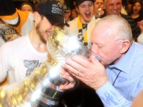 Pittsburgh Penguins general manager Jim Rutherford drinks from the Stanley Cup in the locker room after his team's championship in 2017.