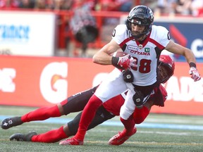 FILE: Calgary Stampeder DaShaun Amos tackles Ottawa Redblacks receiver Brad Sinopoli during CFL action in Calgary on Saturday, June 15, 2019.