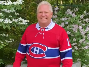 Ontario Premier Doug Ford dons a Guy Lafleur jersey as part of a bet with his Quebec counterpart Francois Legault after the Maple Leafs lost their series with the Habs.