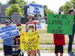 Children and parents protest against school closures near Sir Winston Churchill Public School on Wednesday.