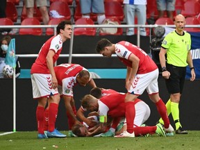 Denmark's Christian Eriksen receives medical attention after collapsing during the match.