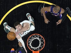 Milwaukee Bucks center Brook Lopez rebounds as Phoenix Suns guard Chris Paul, right, looks on during the first half in Game One of the NBA Finals at Phoenix Suns Arena on July 6, 2021 in Phoenix, Arizona.