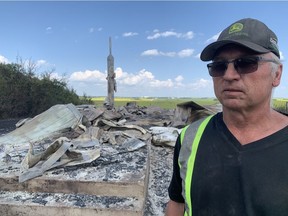 Douglas Swystun, a local farmer, stands in front of what's left of a church after an afternoon fire near Redberry Lake.