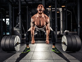 Muscular men lifting deadlift In the gym