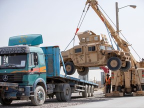 U.S. Army soldiers and contractors load High Mobility Multi-purposed Wheeled Vehicles, HUMVs, to be sent for transport as U.S. forces prepare for withdrawl, in Kandahar, Afghanistan, July 13, 2020.