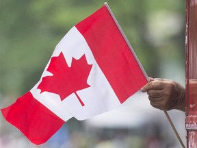 A man waves a flag during a Canada Day parade in Montreal, on July 1, 2018.