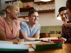 Group Of Gay Friends Meeting At Home And Eating Takeaway Pizza