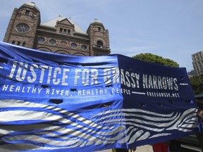 Banner demanding justice for northern Ontario First Nations community Grassy Narrows at Queen's Park in June 2016