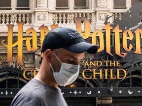 A man wears a mask to prevent against the spread of COVID-19 while he walks around Theater District in Times Square, as the highly transmissible Delta variant has led to a surge in infections, in New York City, July 30, 2021.