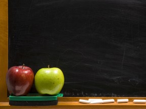 Apples on a chalkboard ledge at school