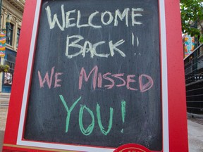 A sign welcomes back customers to indoor dining.