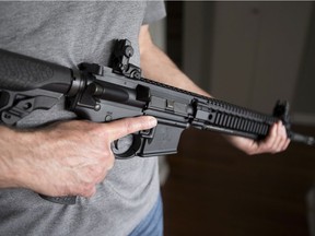 A restricted gun licence holder holds an AR-15 at his home in Langley, B.C. on May 1, 2020.