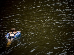 File photo/ People cool off near the Wakefield Covered Bridge in the Gatineau River.