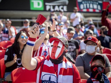 A fan cheering on Atletico Ottawa at TD Place on Saturday.