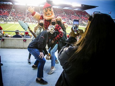 Redblacks mascot Big Joe poses with fans before Saturday's home game against the Lions.
