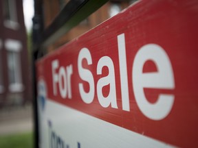 A "for sale" sign is pictured outside a home.