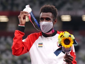 Silver medalist Mohammed Ahmed of Team Canada holds up his medal on the podium during the medal ceremony for the Men's 5000m on day fourteen of the Tokyo 2020 Olympic Games at Olympic Stadium on August 06, 2021 in Tokyo, Japan.