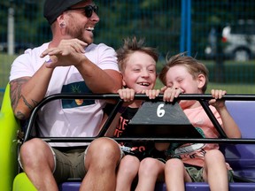 David Verge has a blast with his two boys, Félix, 9, and Mattis, 5, while on the Sizzler at the Kanata Family Fun Fair, which took place this weekend at the Kanata Recreation Complex with safety protocols in place.